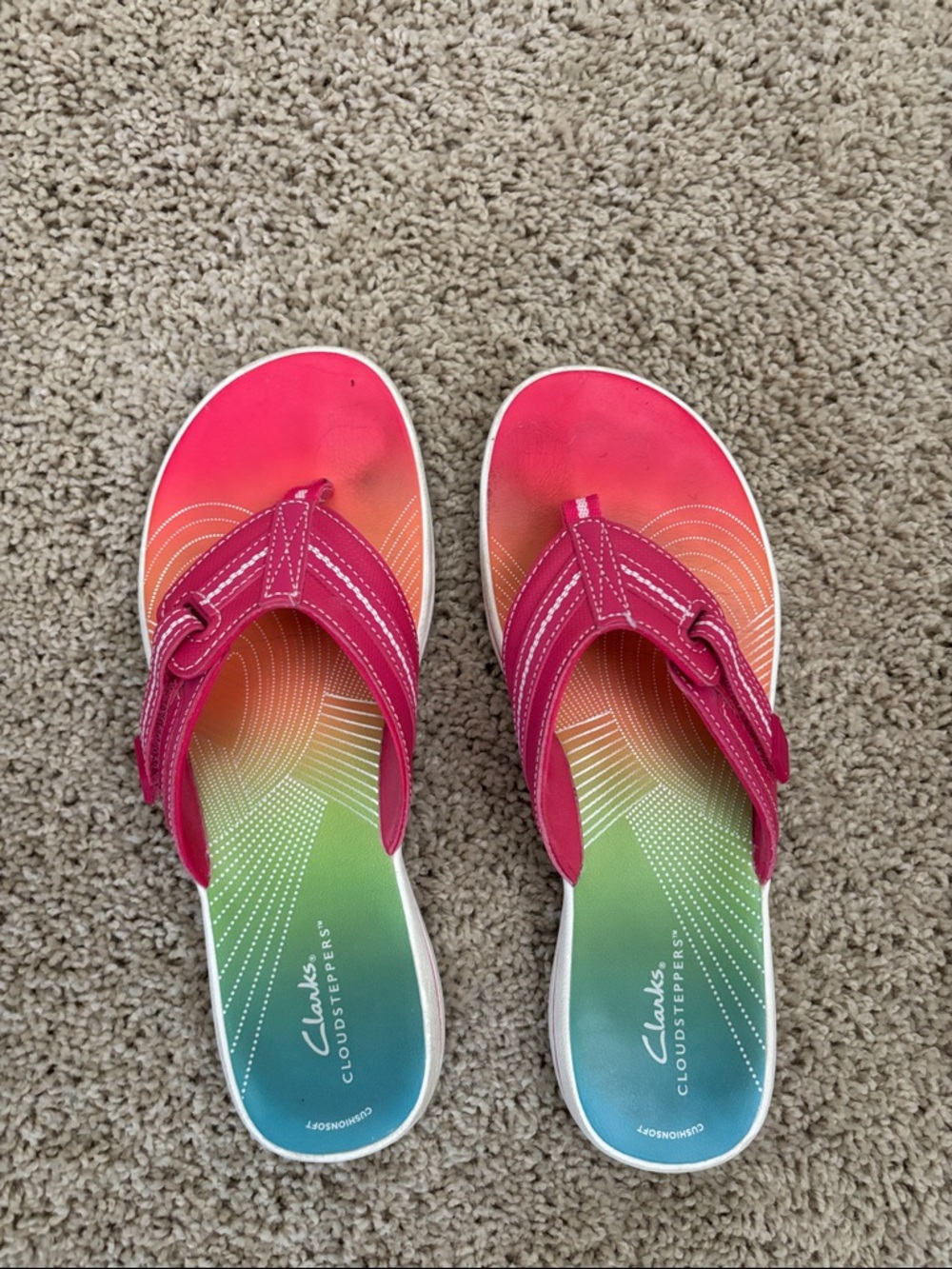 Clark’s pink and rainbow flip flops.